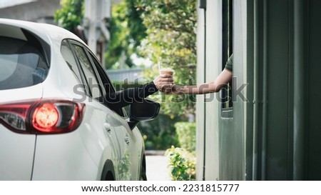 Young Man receiving coffee at drive thru counter., Drive thru and take away for protect covid19. Royalty-Free Stock Photo #2231815777