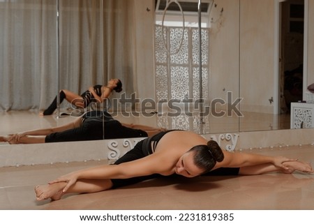 Woman does gymnastics and yoga at home, sport concept
