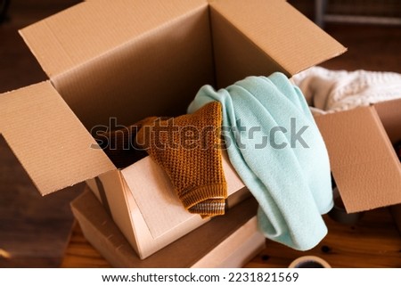 Close up of cardboard box parcel with clothes inside.