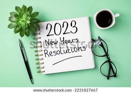 New year resolutions 2023 on desk. 2023 resolutions list with notebook, coffee cup on table. Goals, resolutions, plan, action, checklist concept. New Year 2023 template, copy space Royalty-Free Stock Photo #2231827667
