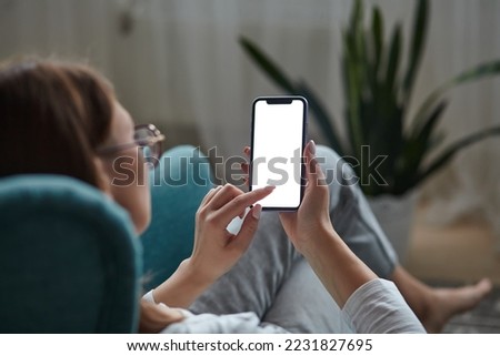 Woman hand holding using touch mobile phone white screen mockup Back view