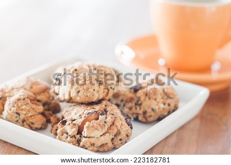 Closeup cereal cookies on white plate with coffee cup, stock photo