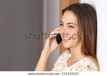 Happy woman talking on the mobile phone at home or office with an unfocused background and copy space