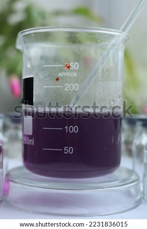 Indicator dye of Congo red has dark violet color in an acidic solution of oxalic acid in a beaker.