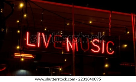 Live music inscription in neon lights at night. Electric sign at night nightlife concept. Modern fluorescent life style luminescent. LED light sign text 