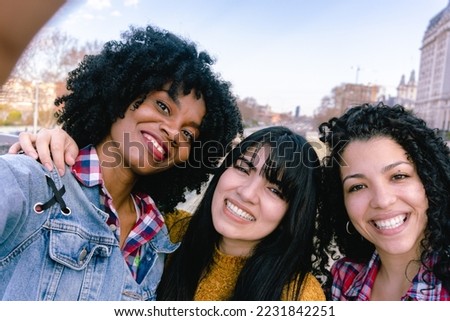 three young female friends taking a selfie in the city, one black Haitian and two Latinas Royalty-Free Stock Photo #2231842251