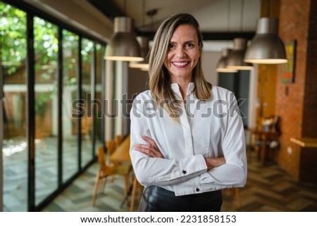 One woman middle age caucasian female standing at home in dining room or restaurant happy smile confident wear white shirt waist up copy space front view portrait Royalty-Free Stock Photo #2231858153