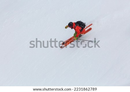 top view of freerider skier making a carving turn on a steep slope, an adrenaline outdoor adventures