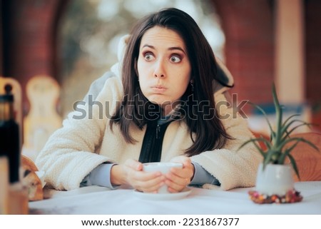 
Woman Trying to Warm Herself in a Restaurant with a Hot Drink. Concerned girlfriend having a coffee waiting for her date
 Royalty-Free Stock Photo #2231867377