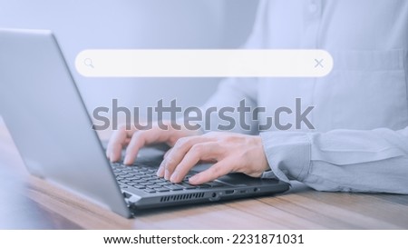 Businessman's hand working with computer laptop on desk in home. Searching Browsing Internet Data Information with blank search bar. Search Engine Optimization SEO Networking Concept.