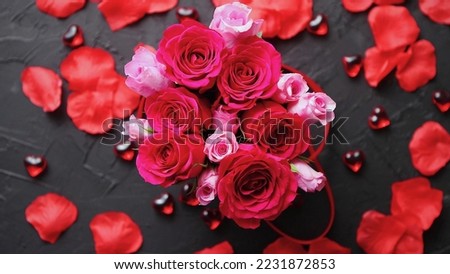 beautiful damask rose decorated together with other pink roses and petals spreaded all around. stock photo, dark color background texture, close up, for valentine, wedding or anniversary.