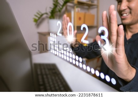 Asian man hold UI interface web map app cloud online to laptop so finger touch online connect app 2023. 2023 new year number logo concept. Year of the rabbit 2023 new technology of people.