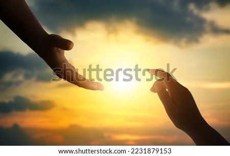 Silhouettes of hands reaching out for hope and supporting each other on sunset background. Royalty-Free Stock Photo #2231879153