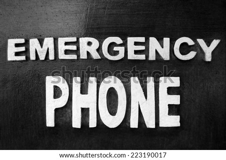 Vintage emergency phone inscription on wooden background (black and white)