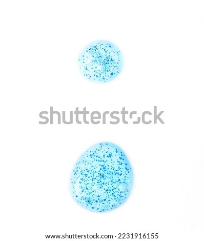 Smear of blue shower gel with scrub grain on white background, top view. Close-up texture peeling cosmetic product. Beauty skin care treatment