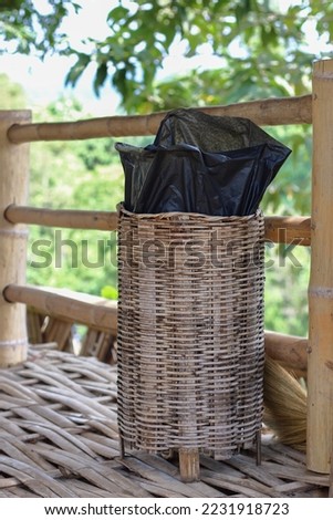 public open basket bin with black plastic bag.