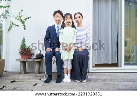 Commemorative photo of three parents and their child at their home