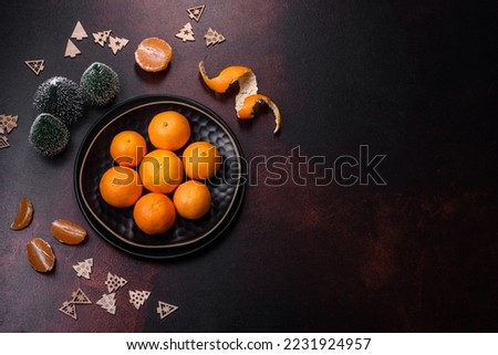 Beautiful Christmas decorations with holiday toys, clementines and gingerbread on a dark concrete background. Preparing the Christmas table