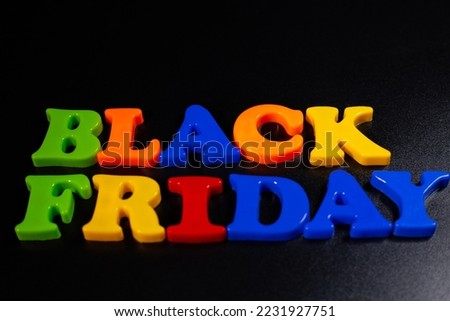 Plastic letters are placed on a black background and the word Black Friday is written. Discounts.