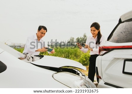 Young man and woman who drive recklessly at speed together take picture with smartphone as evidence of a rear end car accident to prove car insurance claim : Accident and car insurance concept. Royalty-Free Stock Photo #2231932675