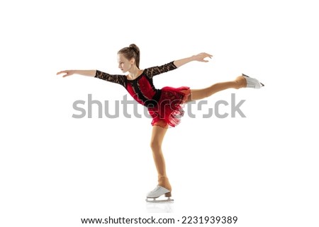 Arabesque. Portrait of little flexible girl, figure skating in stage attire posing isolated on white backgound. Graceful and weightless. Concept of movement, sport, beauty. Copy space for ad, text