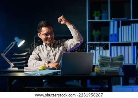 Overtime work concept, Handsome asian business man working late at night in office workplace. Royalty-Free Stock Photo #2231958267