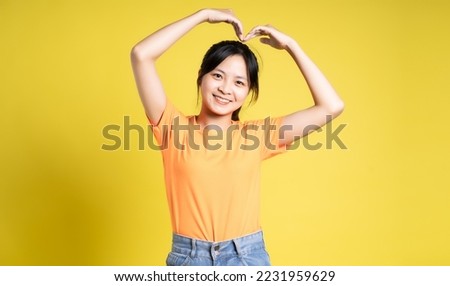Asian girl posing on yellow background