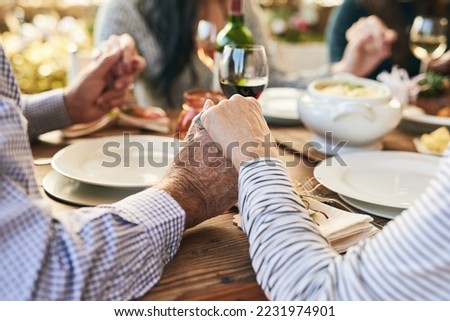 Dinner, holding hands and family prayer at table for thanksgiving celebration with faith, religion and holiday gratitude. Love, social and hand holding of people praying for party, food and wine