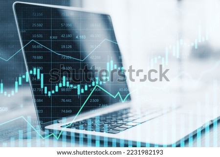 Close up of laptop with glowing business graph hologram and index on blurry background. Finance, trade and invest concept. Double exposure