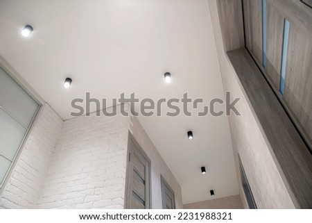 Beautiful black LED lights on the ceiling. Modern stretch ceiling design with lighting. New technologies Royalty-Free Stock Photo #2231988321