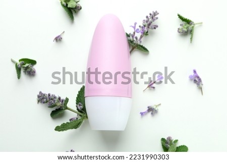 Blank roll-on deodorant and flower twigs on white background