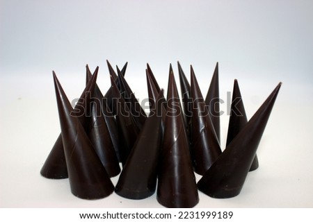 Elongated chocolates are located on white background