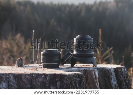 Photographic lenses placed on a stump. Technology for capturing moments, landscapes, people.