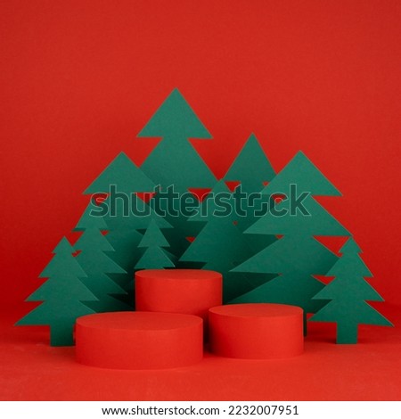 Christmas tradition background - three red scene, cylinder podiums mockup for presentation gifts, cosmetic products, good, green paper spruce forest, square. New year template for card, poster, flyer.