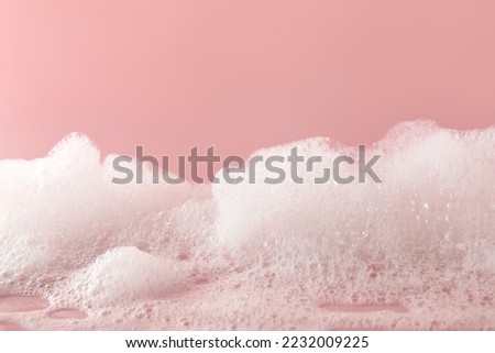 Fluffy bath foam on pink background, closeup Royalty-Free Stock Photo #2232009225