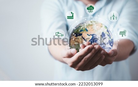 Businessman hold world with CO2 reducing icon for decrease CO2, carbon footprint and carbon credit to limit global warming from climate change, Bio Circular Green Economy concept.Element image of NASA