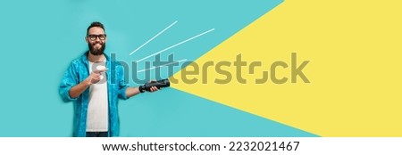 Young bearded hipster man holding a flashlight. Your text here. Discounts, sales, seasonal sales. Colorful summer concept. Modern creative artwork. Royalty-Free Stock Photo #2232021467