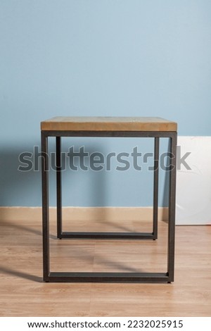 Wooden table in loft style against a blue wall