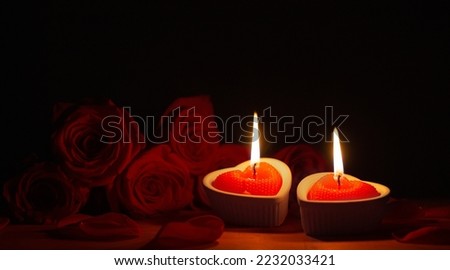 red roses with burning candles on dark background