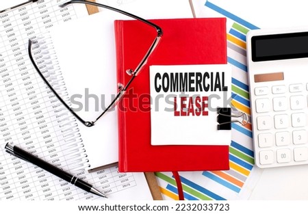 COMMERCIAL LEASE text on a notebook with chart, calculator and pen