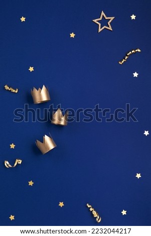 Traditional Three King's Day of January 6. Three gold crowns on blue background. Concept for Dia de Reyes Magos day, three Wise Men. Happy Epiphany day. Top view, copy space, flat lay. Royalty-Free Stock Photo #2232044217
