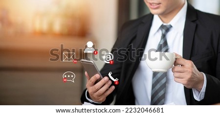 Businessman holding mobile phone with social media icon. Multitasking and busy concept.
