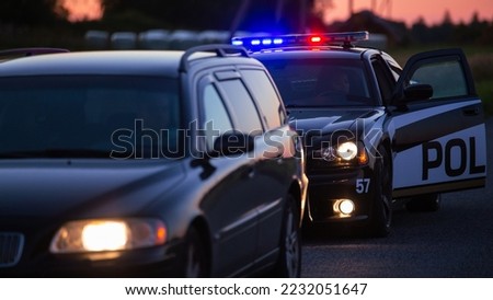 Highway Traffic Patrol Car Pulls over Vehicle on the Road. Male Police Officer Approaches and Asks Driver for License and Registration. Officer of the Law doing Job Professionally. Cinematic Wide Shot Royalty-Free Stock Photo #2232051647