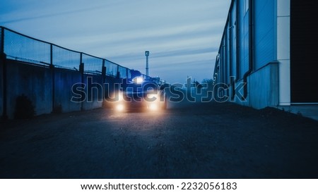 Traffic Patrol Car in Pursuit through Industrial Area. Police Officers Driving Squad Car, Chasing Suspect on Industrial Road, Sirens, High Speed. Cops on Emergency Response Call. Cinematic Action Royalty-Free Stock Photo #2232056183