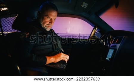 Inside Police Traffic Patrol Squad Car: White Male Police Officer on Duty Uses Laptop to Check Crime Suspect Background, License Plate, License and Registration. Officer of the Law Fight Crime