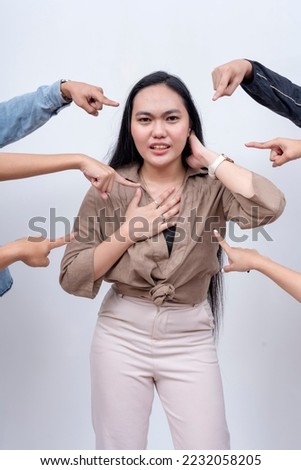 A young woman vehemently denies the charges placed on her. Arms from anonymous people pointing at her. Accusation and trial concept. Court of public opinion. Royalty-Free Stock Photo #2232058205
