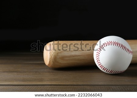 Baseball bat and ball on wooden table. Sports equipment