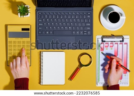 Female hands with items for doing business on a bright colored background
