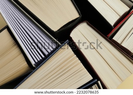 Many hardcover books as background, closeup view