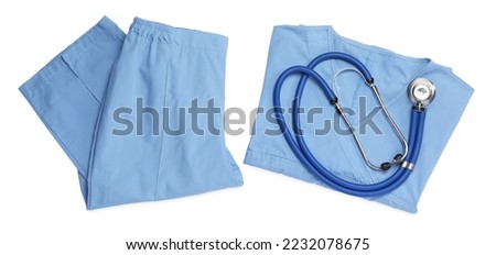 Medical uniform and stethoscope on white background, top view